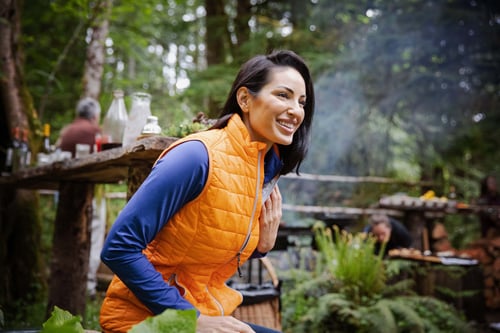 Woman sitting outside wearing Cutter & Buck Rainier PrimaLoft® Womens Eco Insulated Full Zip Puffer Vest