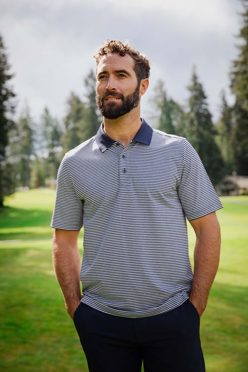 Man on a golf course wearing Cutter & Buck Forge Tonal Stripe Stretch Mens Polo