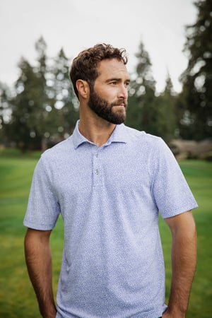 Man wearing an Atlas Blue Cutter & Buck Virtue Eco Pique Botanical Print Recycled Mens Polo during summer