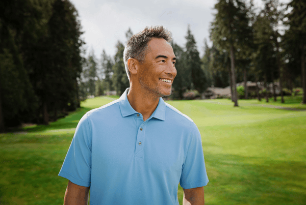 Man on golf course wearing a Cutter & Buck Virtue Eco Pique Recycled Mens Polo