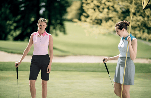 Two women on the golf course wearing cutter and buck pull on womens shorts