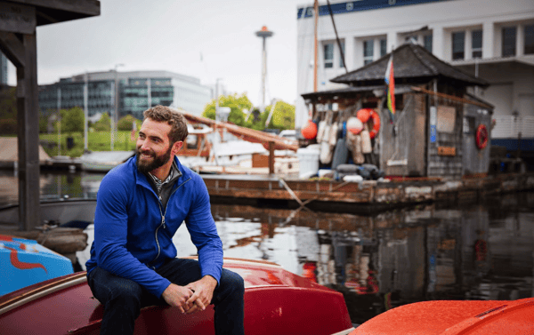 Man sitting on boat wearing Cutter & Buck Adapt Eco Knit Hybrid Recycled Mens Full Zip Jacket