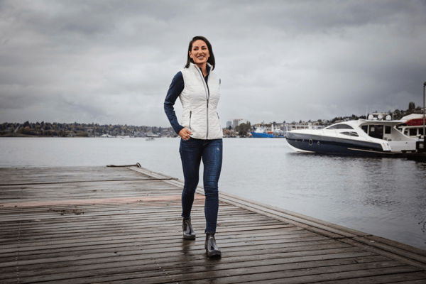 Woman on a dock wearing an eco puffer vest