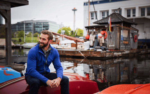 man sitting on boat wearing lightweight jacket