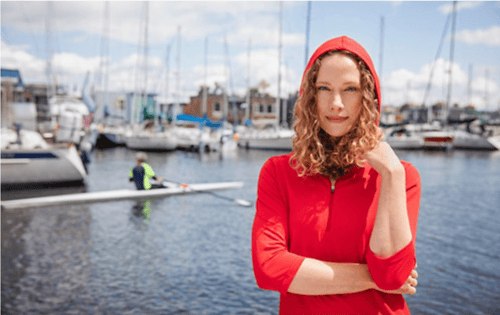 woman at boat dock wearing pullover