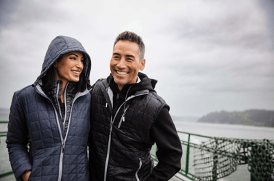 two people on a boat wearing insulated jackets