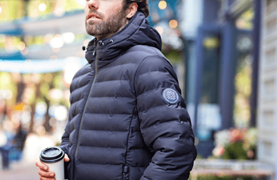 man drinking coffee outside wearing insulated jacket