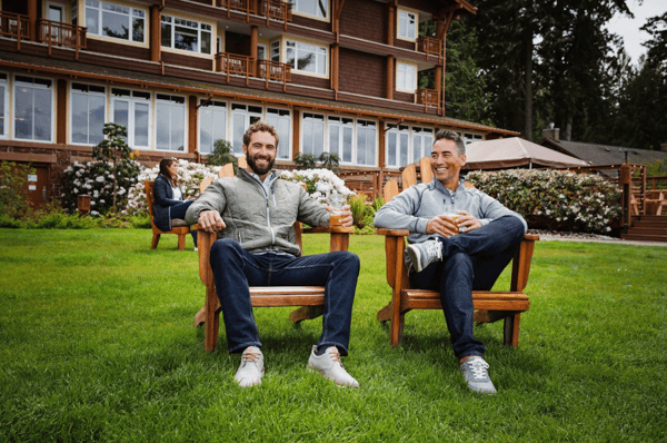 two men sitting on chairs outside