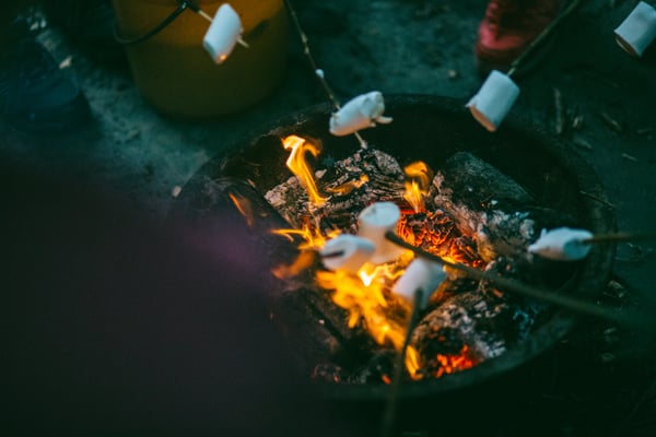 People at a bonfire roasting marshmallows