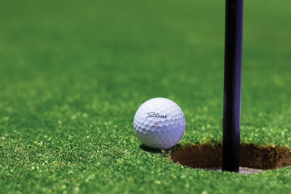 A titleist golf ball near hole