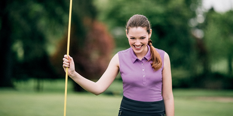 Woman playing golf wearing the Cutter and Buck Clare Sleeveless Polo
